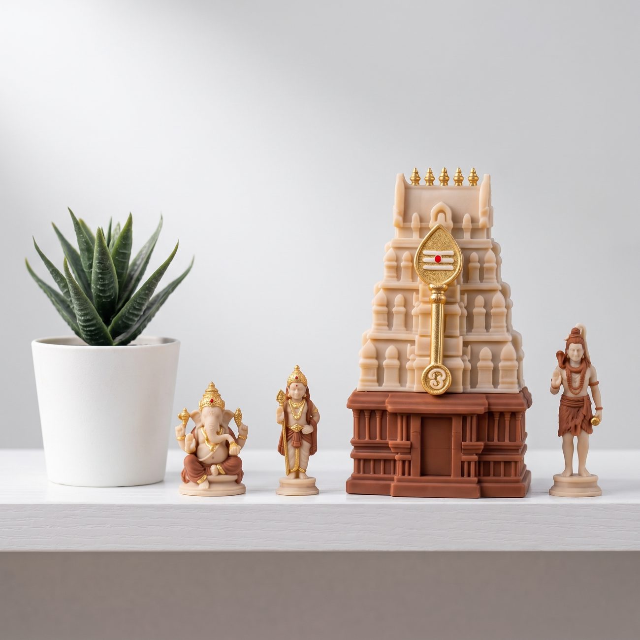 Gopuram and deity figurines on a white shelf